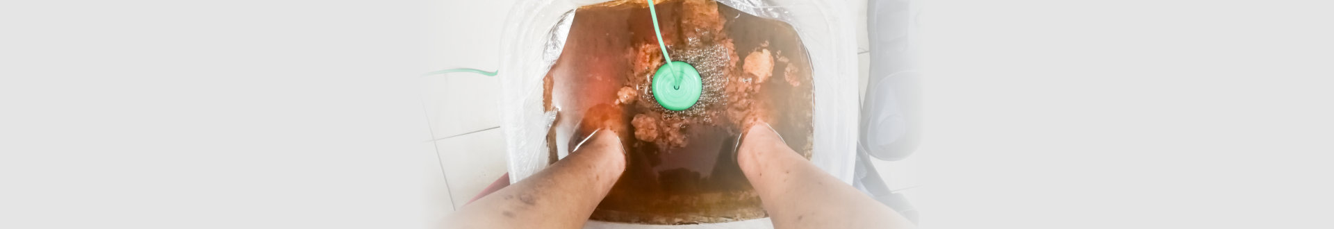 person undergoing foot detox treatment with ion cleansing detox machine