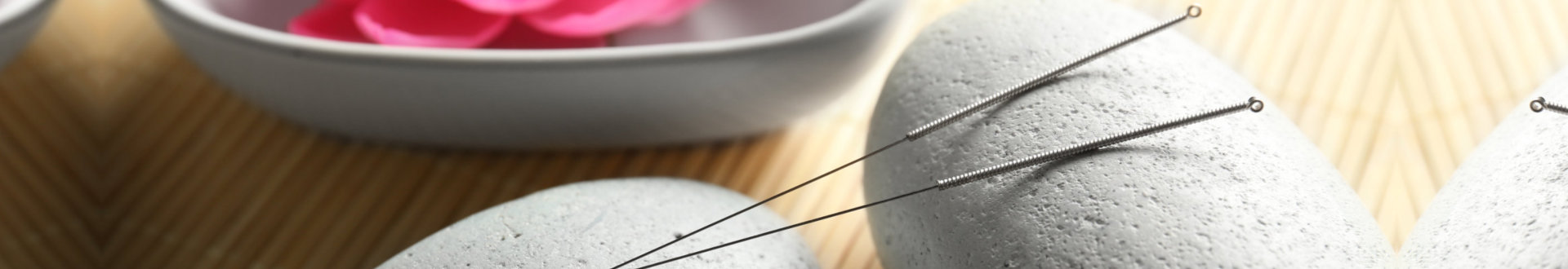 Acupuncture needles with stones on bamboo mat